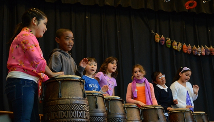 kids playing congas on stage